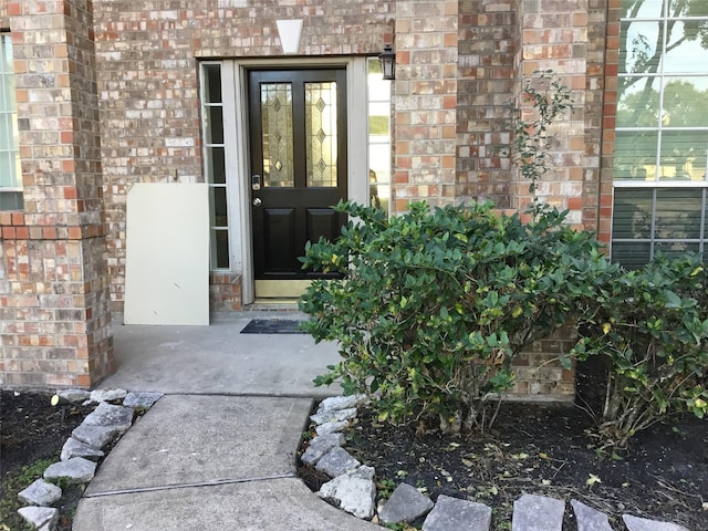 view of exterior entry with french doors and brick siding