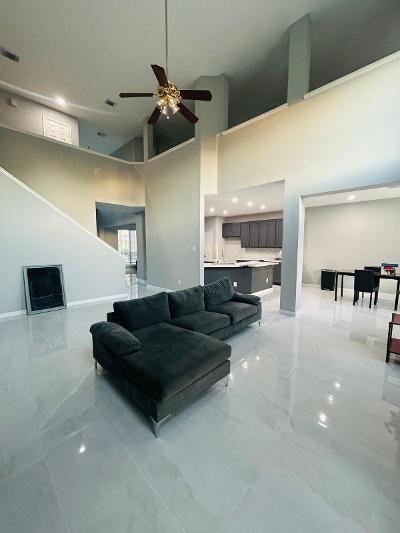 living room with ceiling fan and a towering ceiling