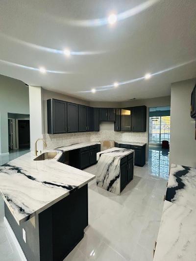 kitchen with kitchen peninsula, decorative backsplash, light stone countertops, and sink