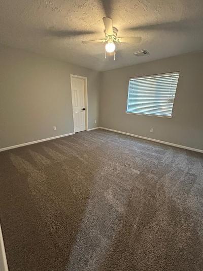 carpeted empty room featuring ceiling fan and a textured ceiling