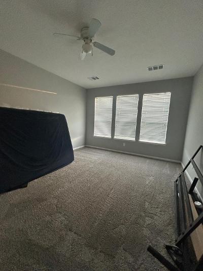 unfurnished bedroom with ceiling fan and carpet floors