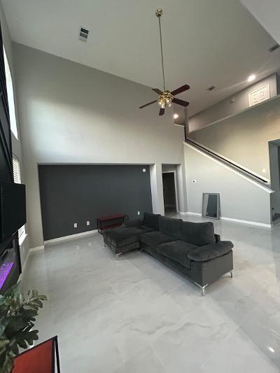 living room featuring a towering ceiling and ceiling fan