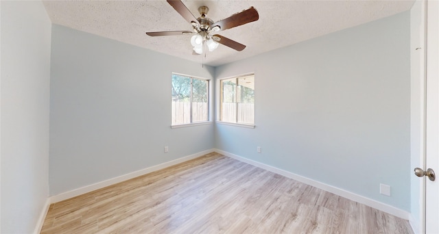 empty room with ceiling fan, light hardwood / wood-style floors, and a textured ceiling