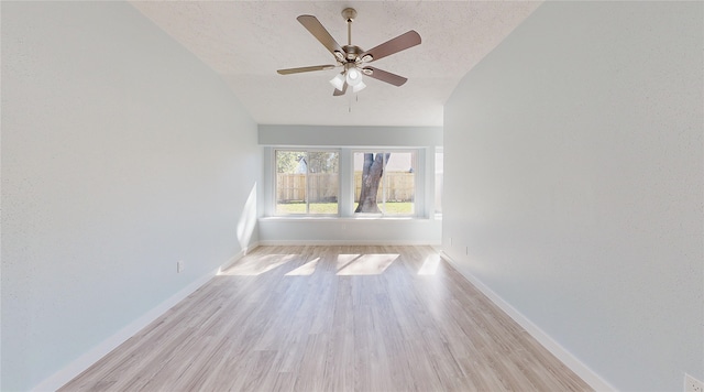 unfurnished room with a textured ceiling, light hardwood / wood-style flooring, ceiling fan, and vaulted ceiling