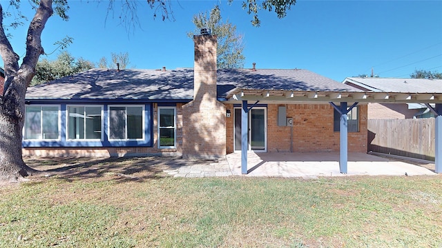 back of house with a patio and a lawn