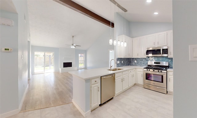 kitchen featuring sink, hanging light fixtures, ceiling fan, appliances with stainless steel finishes, and kitchen peninsula