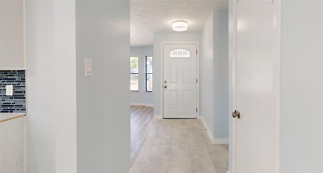 entrance foyer with light wood-type flooring and a textured ceiling