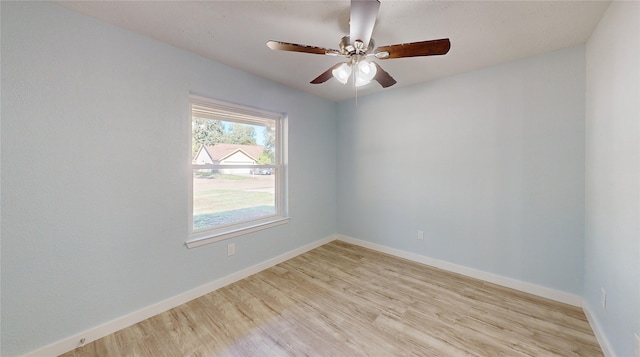 empty room with ceiling fan and light hardwood / wood-style floors