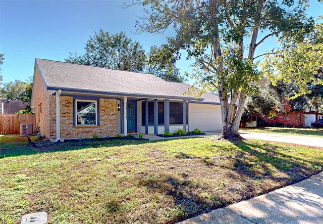 ranch-style home featuring a garage, a front yard, and central AC