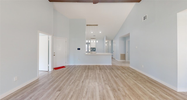 unfurnished living room featuring beam ceiling, light hardwood / wood-style floors, and high vaulted ceiling