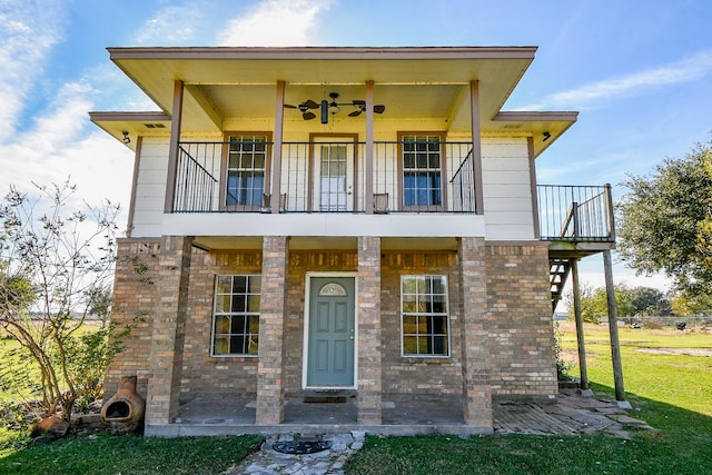 view of front of house featuring a front lawn, a balcony, and ceiling fan