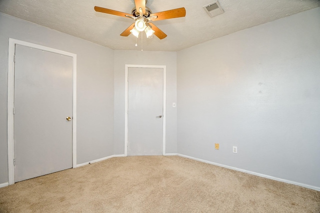 unfurnished room featuring carpet flooring, a textured ceiling, and ceiling fan