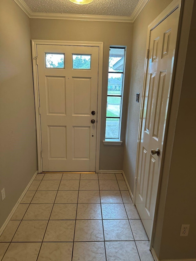 foyer entrance featuring light tile patterned floors, plenty of natural light, crown molding, and a textured ceiling