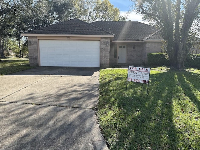 single story home featuring a garage and a front yard