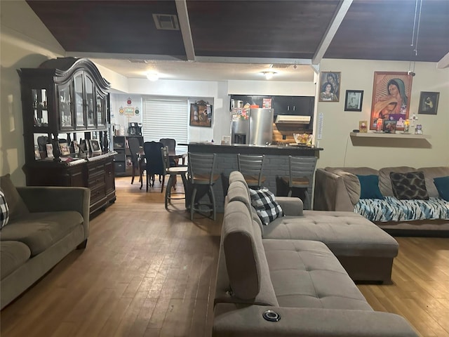 living room with indoor bar and hardwood / wood-style flooring