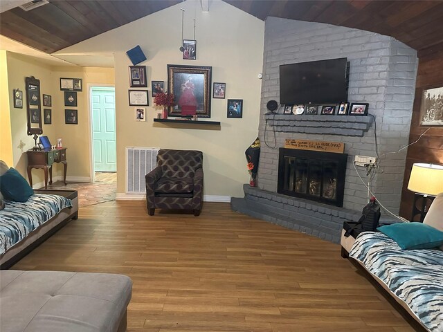 living room featuring a brick fireplace, hardwood / wood-style floors, and vaulted ceiling