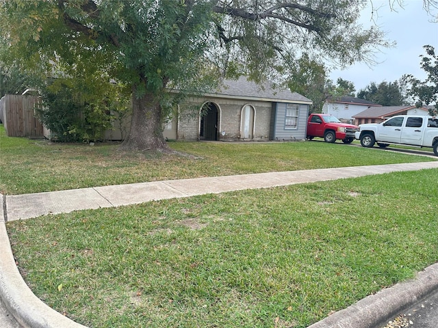 single story home featuring a front lawn