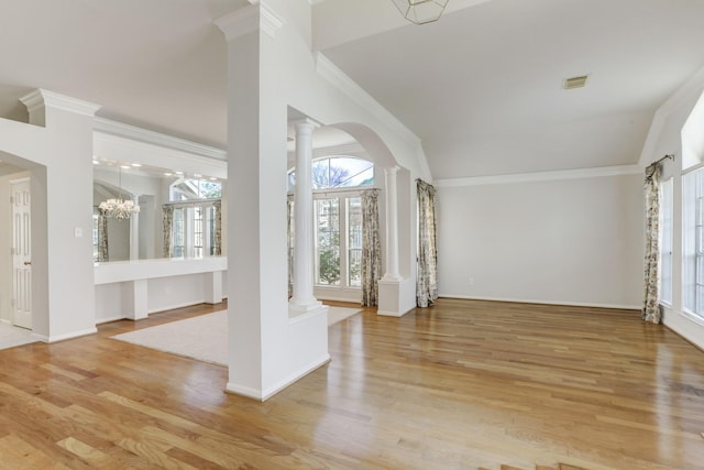 foyer featuring decorative columns, light wood-type flooring, crown molding, and an inviting chandelier