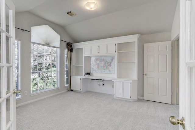 interior space featuring light colored carpet and lofted ceiling