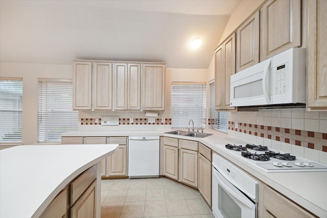 kitchen featuring vaulted ceiling, a wealth of natural light, sink, and white appliances