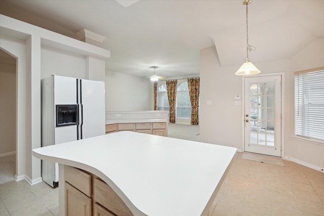 kitchen featuring ceiling fan, white refrigerator with ice dispenser, light tile patterned floors, decorative light fixtures, and a center island