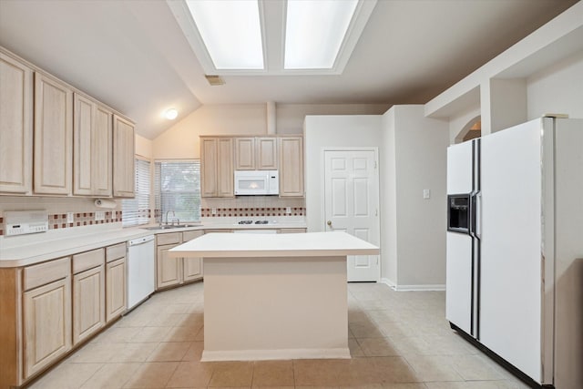 kitchen with vaulted ceiling, a center island, white appliances, and light brown cabinets