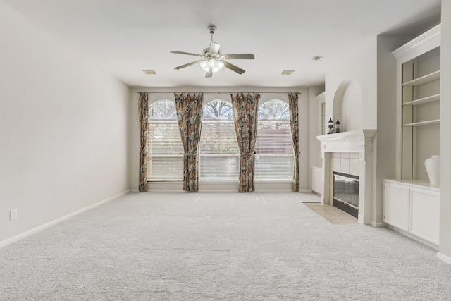 unfurnished living room featuring ceiling fan, light colored carpet, and a tiled fireplace