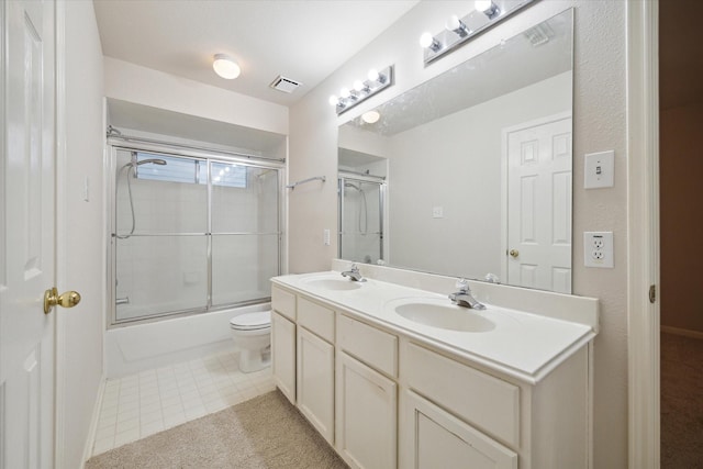 full bathroom with vanity, bath / shower combo with glass door, and toilet