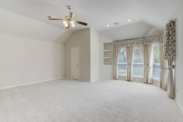 interior space with ceiling fan, light colored carpet, and lofted ceiling