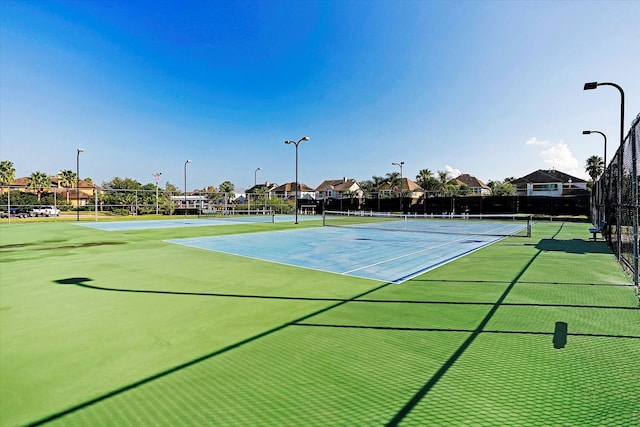 view of tennis court with basketball hoop