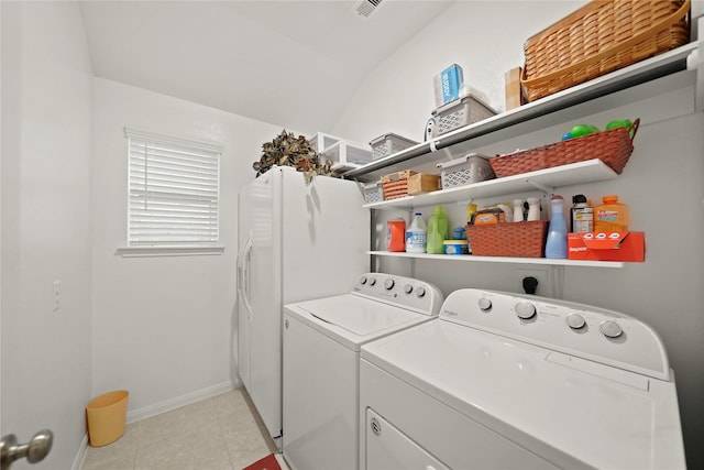 clothes washing area featuring light tile patterned floors and washer and clothes dryer