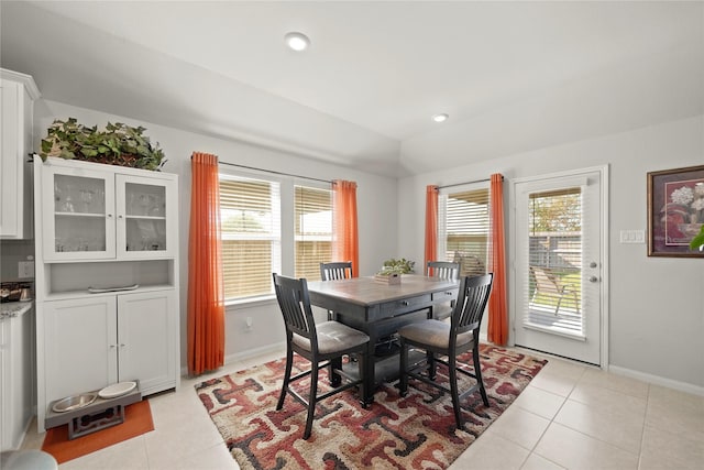 dining area featuring light tile patterned flooring and vaulted ceiling