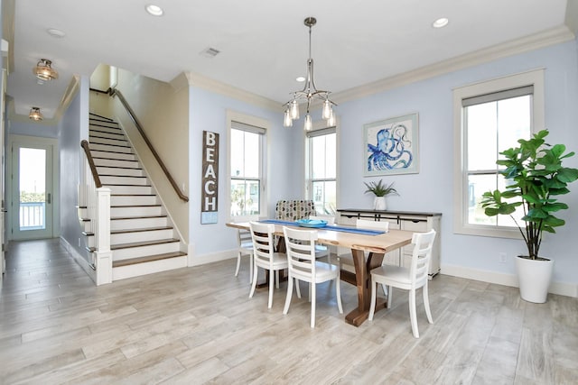 dining room with a healthy amount of sunlight, light hardwood / wood-style floors, and ornamental molding