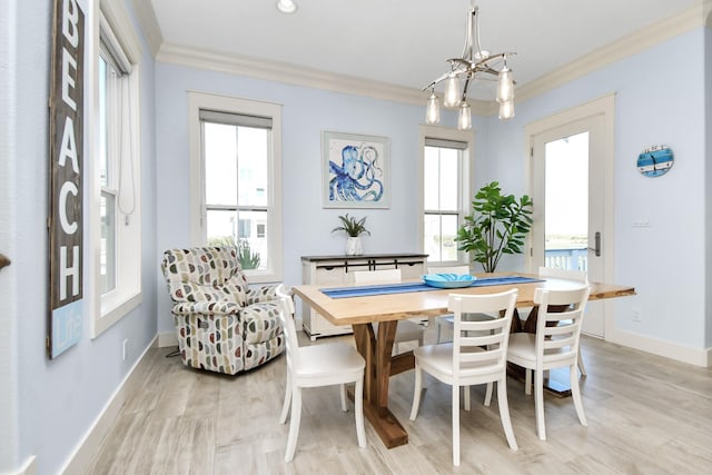 dining space featuring light wood-type flooring, an inviting chandelier, and ornamental molding