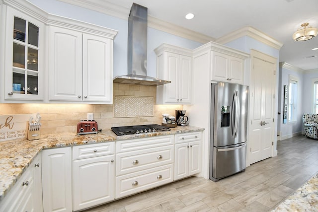 kitchen featuring wall chimney exhaust hood, stainless steel fridge with ice dispenser, black gas cooktop, backsplash, and white cabinets