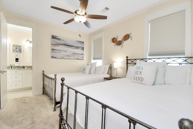 carpeted bedroom featuring multiple windows, ensuite bath, ceiling fan, and ornamental molding