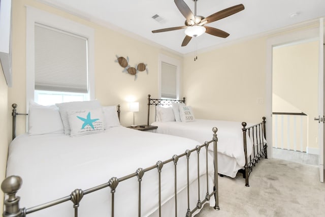 carpeted bedroom with ceiling fan and crown molding