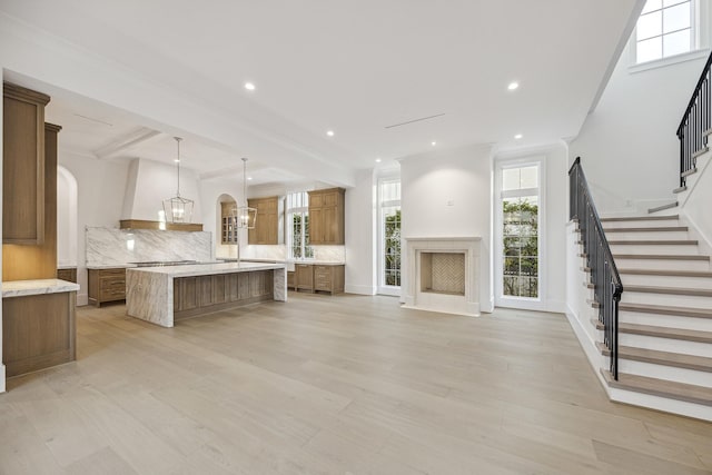 kitchen with pendant lighting, light wood-type flooring, and backsplash