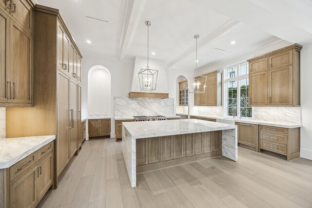 kitchen featuring beamed ceiling, decorative backsplash, pendant lighting, and light hardwood / wood-style flooring