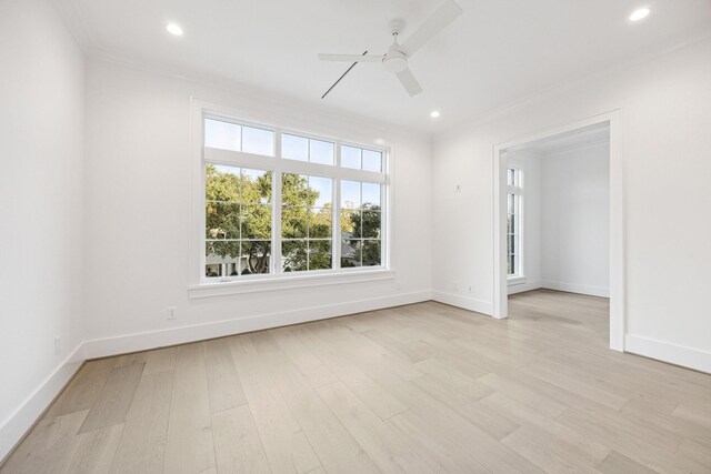 empty room with ceiling fan, light wood-type flooring, and crown molding