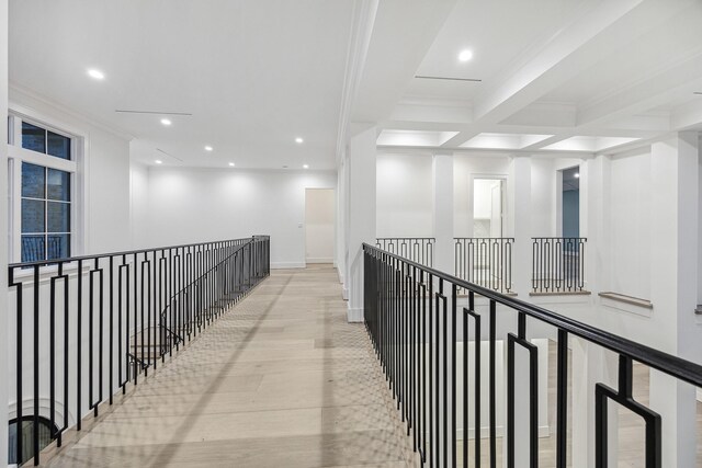 hallway with beamed ceiling, light wood-type flooring, crown molding, and coffered ceiling