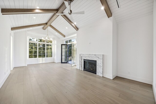 unfurnished living room featuring a high end fireplace, wood ceiling, ceiling fan with notable chandelier, light hardwood / wood-style flooring, and beamed ceiling