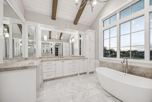 bathroom featuring vanity, a healthy amount of sunlight, vaulted ceiling with beams, and a tub