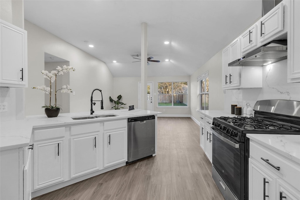 kitchen with appliances with stainless steel finishes, light stone counters, white cabinetry, and sink