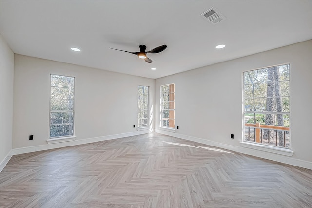 unfurnished room featuring light parquet flooring, a wealth of natural light, and ceiling fan