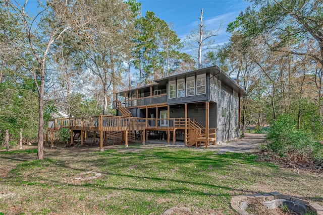 rear view of property featuring a yard and a deck