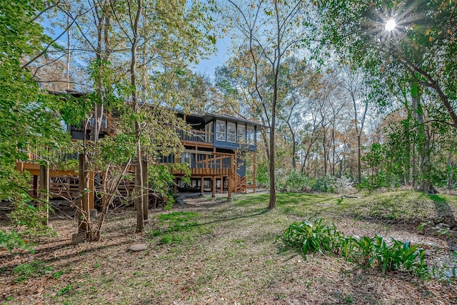 view of yard featuring a wooden deck and a sunroom