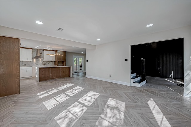 unfurnished living room featuring french doors and light parquet floors