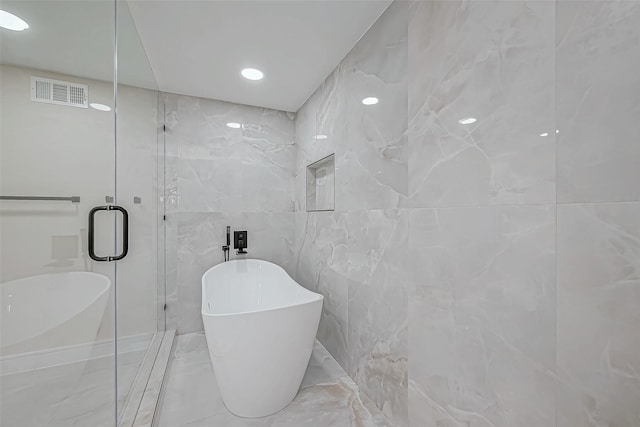 bathroom featuring tile walls and shower with separate bathtub