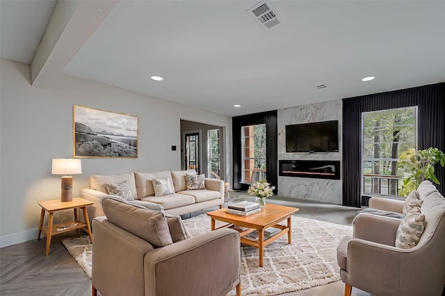 living room featuring a high end fireplace and light parquet floors